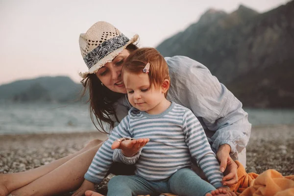 Linda niña con su madre jugando en una playa en el día de verano. Viajes en familia y concepto de vacaciones —  Fotos de Stock