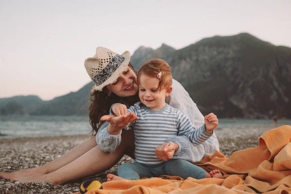 Милая маленькая девочка с матерью, играющей на пляже в летний день. Концепция семейного путешествия и отдыха — стоковое фото