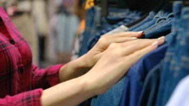 Bir denim giyim mağazasında genç bir kadın alışveriş elleri