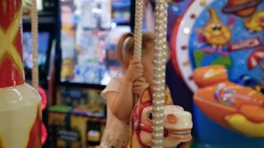 Mutlu küçük beyaz kız oyun odasında bir at atlıkarınca sürme