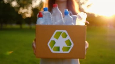 Genç kimliği belirsiz kadın tutar ve plastik şişe ile bir kutu eller