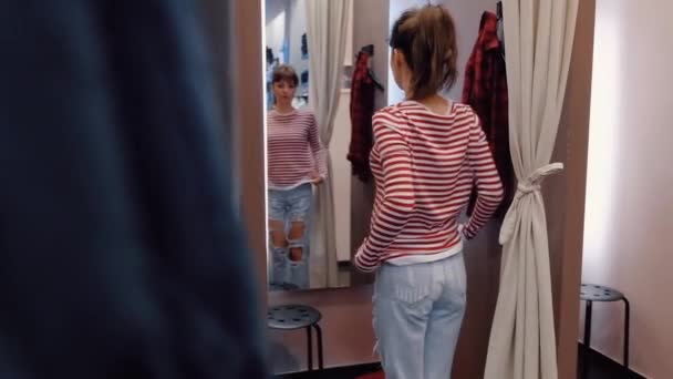 Jovem encantadora experimenta jeans elegantes de denim leve — Vídeo de Stock