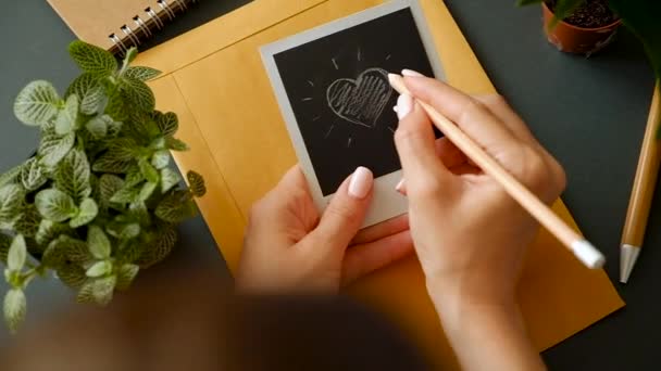 一个年轻女孩的手的特写用一个美丽的美甲画一颗心 — 图库视频影像