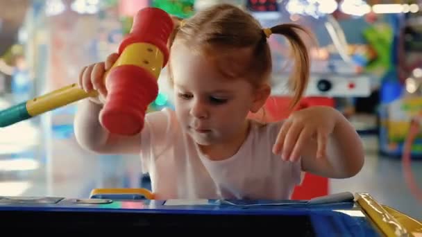 Porträt eines hübschen kleinen Mädchens mit Pferdeschwanz, das mit einem Spielautomaten spielt — Stockvideo