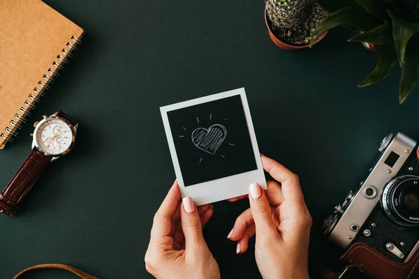 Flat lay female hand holds polaroid picture — Stock Photo, Image