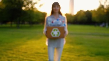 Genç kimliği belirsiz kadın tutar ve plastik şişe ile bir kutu eller