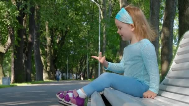 Linda niña sonriente en ropa azul muestra alegremente su edad en sus dedos — Vídeos de Stock