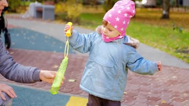 Charmante petite fille en vêtements d'automne agitant une baguette — Video