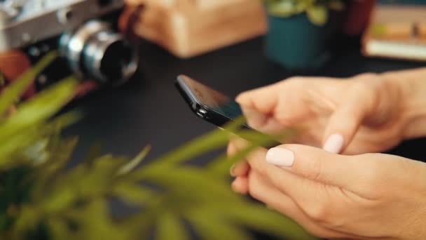 Primer plano de las manos de una joven desconocida sentada en una mesa — Vídeo de stock