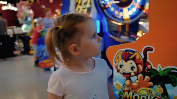 Kaukasische meisje wandelen rond de hal met speelautomaten — Stockvideo