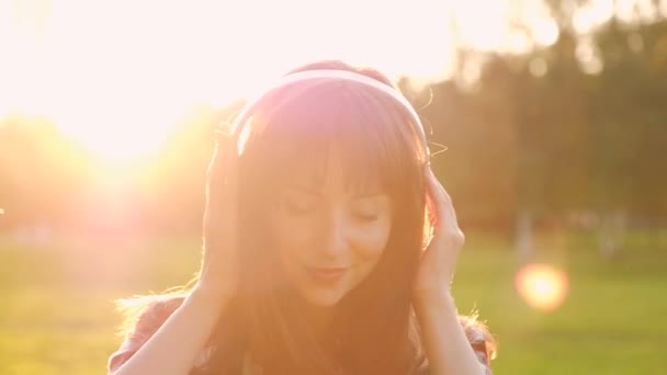 Portret van een mooie sensuele jonge vrouw die naar muziek luistert — Stockvideo