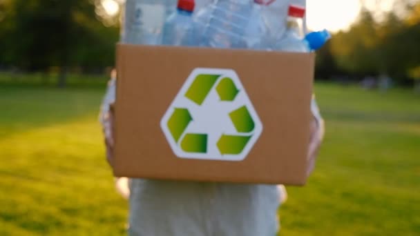 Ung oidentifierad kvinna håller och händer en låda med plastflaskor — Stockvideo