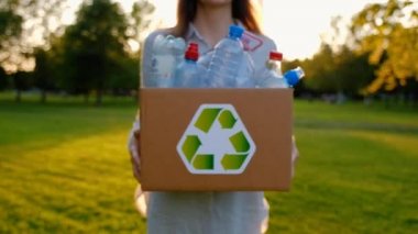 Genç kimliği belirsiz kadın tutar ve plastik şişe ile bir kutu eller