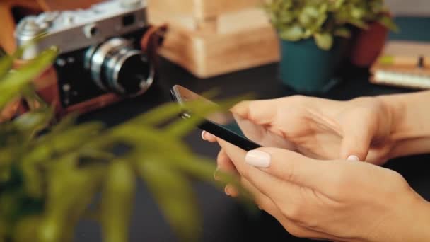 Primer plano de las manos de una joven desconocida sentada en una mesa — Vídeo de stock