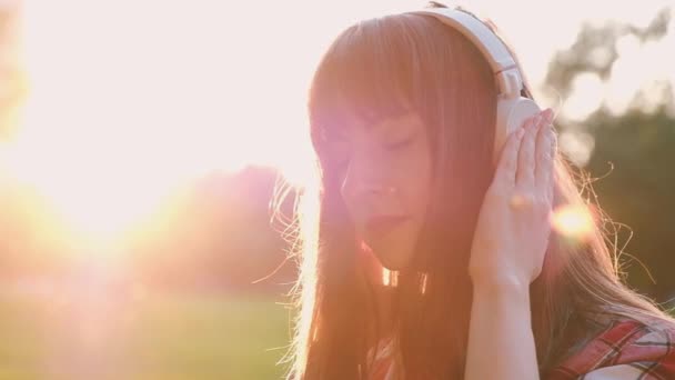 Close-up of a beautiful young charming woman listening to her favorite music — Stock Video