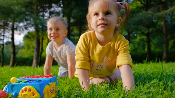 Gros plan petit frère et sœur charmant s'amuser sur la pelouse — Video