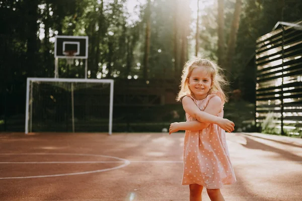 Симпатична Маленька Дівчинка Рожевій Повсякденній Сукні Посміхається Стоячи Спортивному Корті — стокове фото