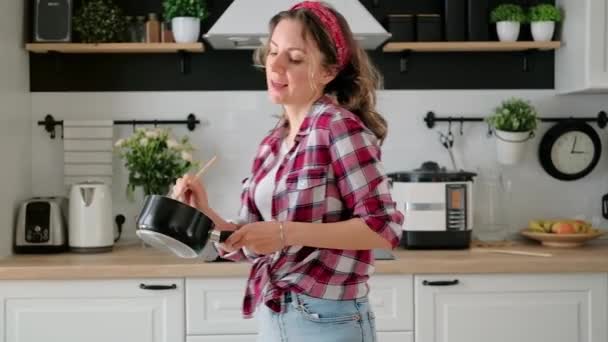 Insouciante jeune femme heureuse femme au foyer dansant seul repas de cuisine — Video