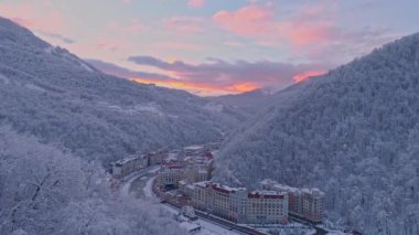 Gül günbatımı Rosa Khutor Kayak Merkezi kışın dağlarda bir hava dron kadeh. Kış beyaz, kar kaplı orman.