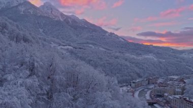 Hava dron Rosa Khutor kışın gül günbatımı atış Dağları'nda kurulması. Düşük uçuş yukarıdaki kar örtmek ağaçlarıyla dışarı geniş sahne.