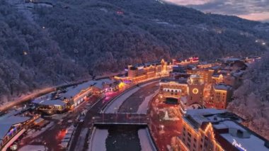 Hava dron vurdu. Rosa Khutor Kayak Merkezi Sochi yukarıda uç. akşam aydınlatma. Kar orman kaplı. İleri Nehri üzerinde uçan.