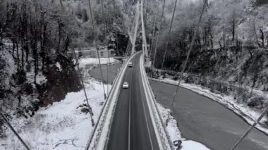 Havadan görünümü uç kablo köprü araba trafiği olan boyunca. Uçuş dikmesi arasında. Karlı kış beyaz manzara. Kablo Soçi den köprüye Krasnaya Polyana, Estosadok kaldı.
