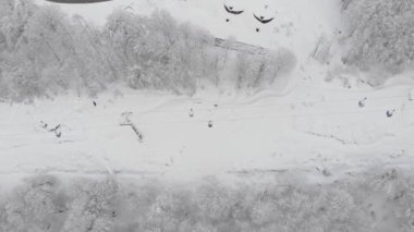 Teleferik teleferik kaldırma hava üstten görünüm. Füniküler, telesiyej Kayak merkezinde. Dron statik dikey atış. Orman, beyaz kış manzara dağlarda kar kaplı. Kayak pisti.