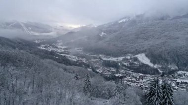 Havadan görünümü dağlar şehir uçmak. Yalnız chalet aralıktaki. Radyo kulesi dağlarda. Karla kaplı, bulutlar, ev sahipliği yapmaktadır. Geriye dönük drone uçuş.