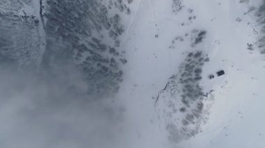 Teleferik bulutlar altında en iyi görünümü. Teleferik yukarıya taşımak yoğun bulutlar telesiyej. Yukarıdan aşağıya dikey hava atış. Kış karla kaplı dağlar. Forest Hills