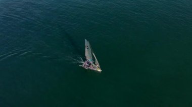 Yelken yarışı sırasında yelkenlinin üzerinden hava dansı uçuşu