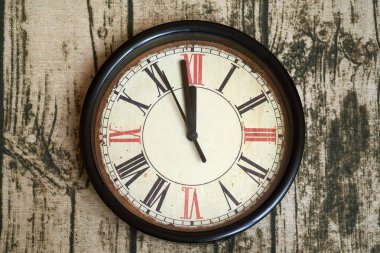 Saat neredeyse on iki gösterilen Roma numaraları ile eski stil klasik saat. Zaman neredeyse gitti ya da geldi, ahşap doku arka plan, önden görünüm