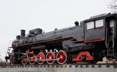 Eski klasik siyah Buhar lokomotif tren yolu üzerinde kırmızı süslemeli yan görünüm