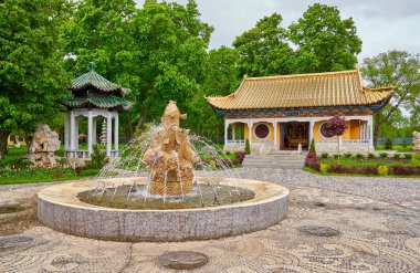 yeşil park üzerinde taş çeşme ve geleneksel Çince Budist Tapınağı ile göster