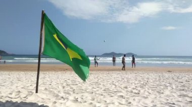 Ilha Grande, Rio de Janeiro, Brezilya - Kasım 2018. Lopez Mendes Plajında Futbol Oynayan İnsanların Arkaplanında Brezilya Bayrağı sallamak.