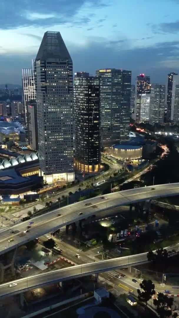 夜のシンガポールダウンタウンエリアの垂直空中ビュー 夜に沿って道路高速道路 現代都市景観スカイライン — ストック動画