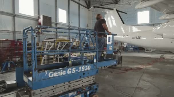 Great Falls, Montana, USA - JULY 2015. In a Hangar Aircraft Maintenance Engineer Technician Mechanic Inspects Airplane Jet Wing. — Stock Video