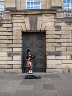 Edinburgh İskoçya - 26 Temmuz: A Scotsman bagpipes Royal Mile boyunca 26 Temmuz 2017 Edinburgh, İskoçya'da oynamaya geleneksel İskoç kıyafeti giymiş. Birçok pipers busking çoğu.