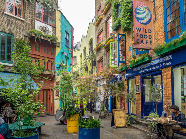 ЛОНДОН Великобритания - AUG 2: Neals Yard with unidentifed people in August 2, 2017 in London, England. Это небольшая аллея в Ковент-Гарден с красочными домами и несколькими кафе здоровой пищи и ценностей розничной торговли

