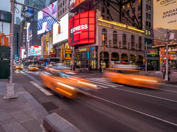 New York, New York - March 29, 2018: Famous New York City yellow cabs streaking through Times Square early in the morning.