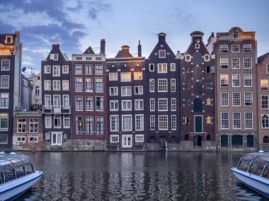 Damrak kanal geceleri güzel Amsterdam merkezinde tarihi binalar.