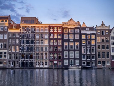 Damrak kanal geceleri güzel Amsterdam merkezinde tarihi binalar.
