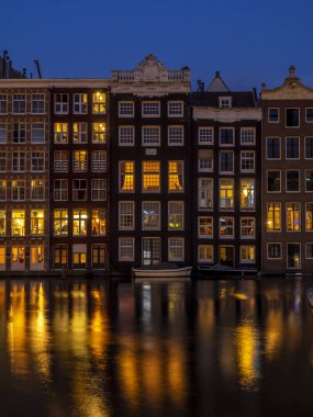 Damrak kanal geceleri güzel Amsterdam merkezinde tarihi binalar.