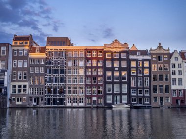Damrak kanal geceleri güzel Amsterdam merkezinde tarihi binalar.