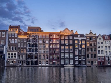 Damrak kanal geceleri güzel Amsterdam merkezinde tarihi binalar.