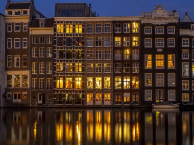 Damrak kanal geceleri güzel Amsterdam merkezinde tarihi binalar.