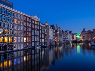 Geleneksel kanal üzerinde Damrak gece karanlığında Amsterdam'da ev sahipliği yapmaktadır. Kanaldaki binalar şimdi çok popüler olan geleneksel Hollanda mimari biçimidir.