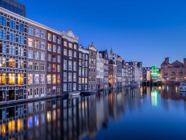 Geleneksel kanal üzerinde Damrak gece karanlığında Amsterdam'da ev sahipliği yapmaktadır. Kanaldaki binalar şimdi çok popüler olan geleneksel Hollanda mimari biçimidir.