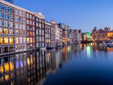 Geleneksel kanal üzerinde Damrak gece karanlığında Amsterdam'da ev sahipliği yapmaktadır. Kanaldaki binalar şimdi çok popüler olan geleneksel Hollanda mimari biçimidir.