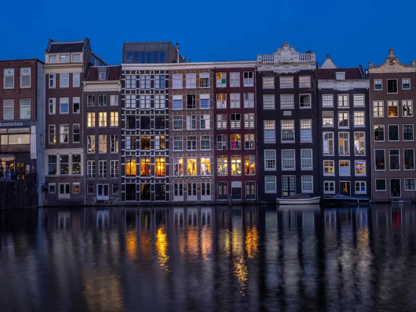 Geleneksel kanal üzerinde Damrak gece karanlığında Amsterdam'da ev sahipliği yapmaktadır. Kanaldaki binalar şimdi çok popüler olan geleneksel Hollanda mimari biçimidir.