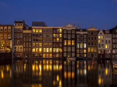Geleneksel kanal üzerinde Damrak gece karanlığında Amsterdam'da ev sahipliği yapmaktadır. Kanaldaki binalar şimdi çok popüler olan geleneksel Hollanda mimari biçimidir.